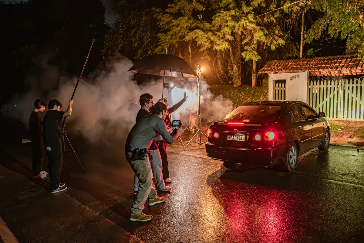 Equipe filmando o carro na rua com fumaca